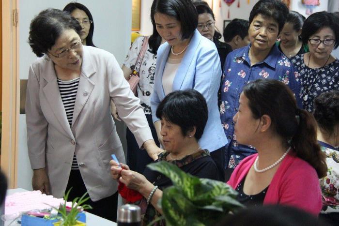 国务院妇女儿童工作委员会成员、中国关工委常务副主任刘雅芝查看妇联微商城手工编织产品.jpg