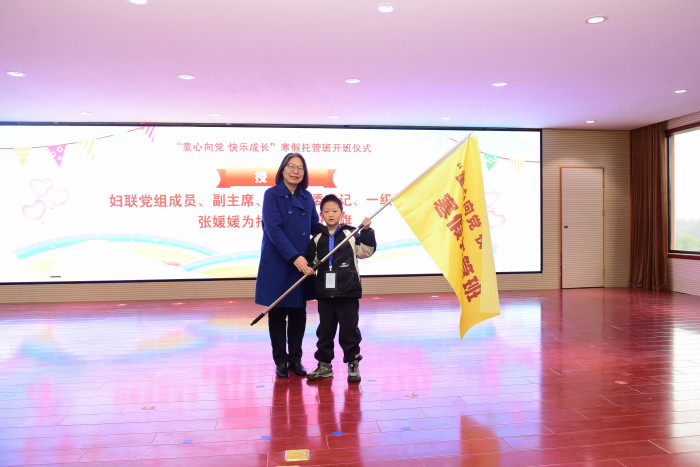 省妇联党组成员、副主席、机关党委书记、一级巡视员张媛媛为托管班大班授旗，请曾楚梵同学上台代表托管班大班接旗.JPG