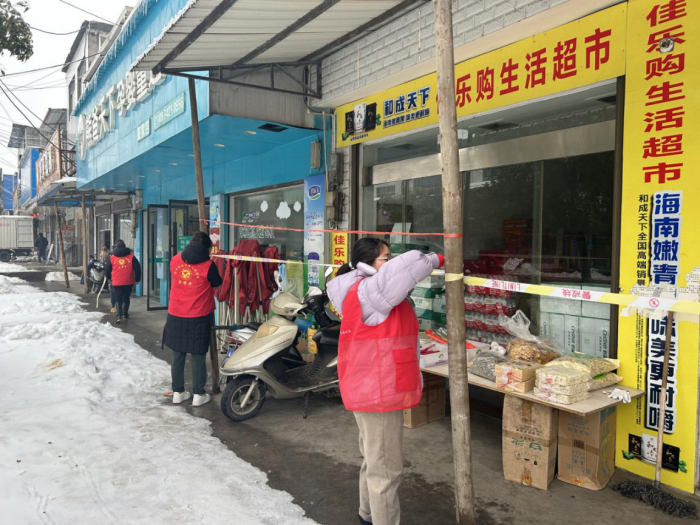安全乡巾帼志愿者对商户门店有安全隐患的钢架棚拉警戒线.png