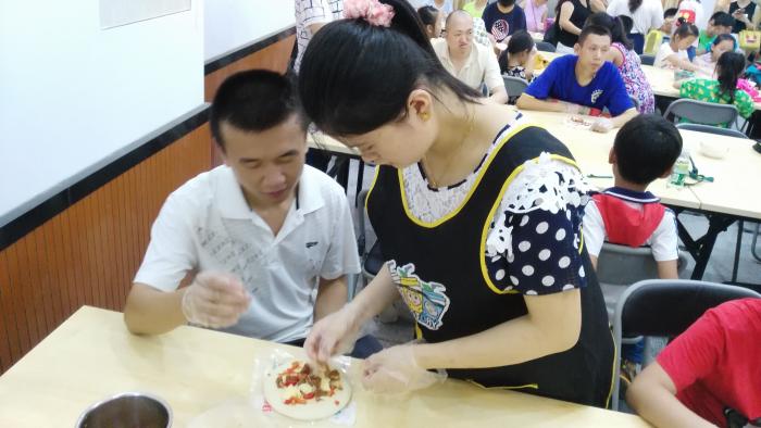 志愿者耐心指导智障青少年制作披萨.jpg