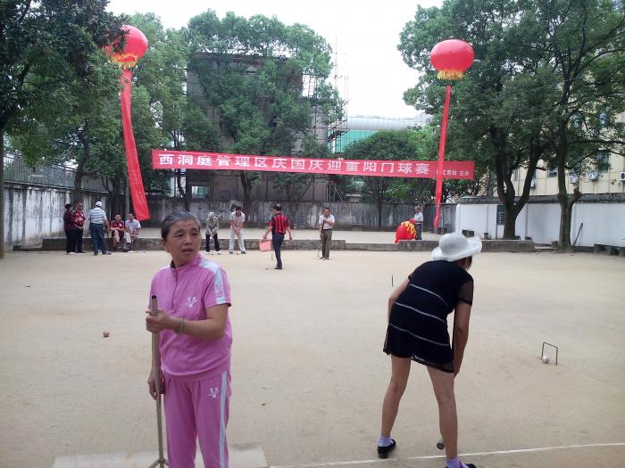 管理区妇联退休妇女干部缪令祥在清扫门球比赛场地.jpg