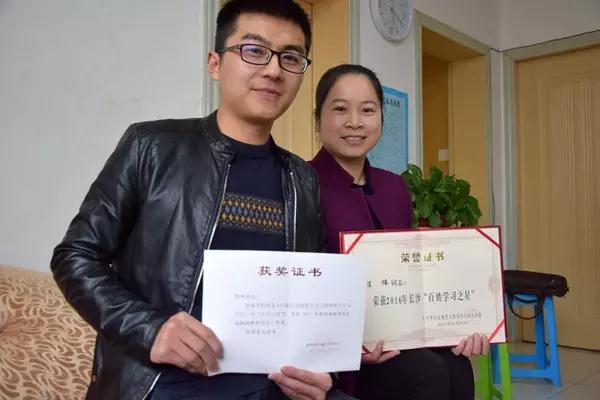 月湖周再兴—程伟和周婷展示荣誉证书，分别为湖南省新闻奖和2016年度“百姓学习之星”。.jpg