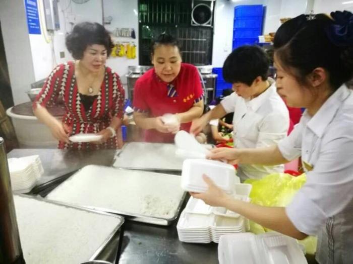 图为喜龙餐饮爱心团队打包盒饭.jpg