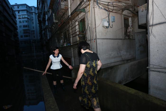 “小心脚下”天黑以后，谭颖婕用身体挡住走廊缺口，站在楼道口引导居民回家.JPG