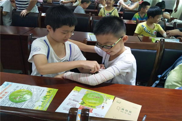 孩子们两人一组相互练习包扎.jpg