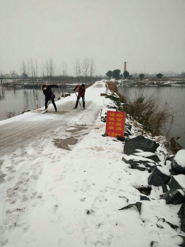 枫树乡红旗村妇联主席曾祥林在桥上铲雪.jpg