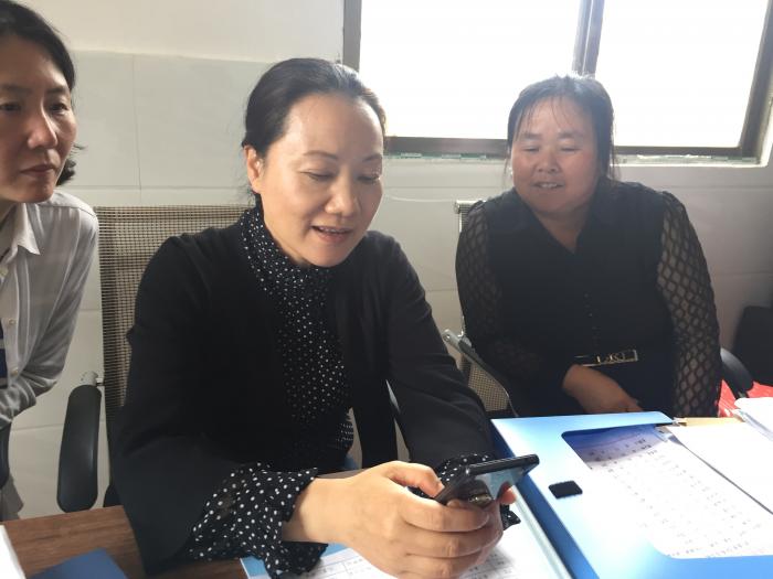 在武冈市湾头桥镇泉塘村，姜欣现场教村妇联主席刘国梅（右一）如何更好地使用网络新媒体，联系服务更多妇女群众.JPG