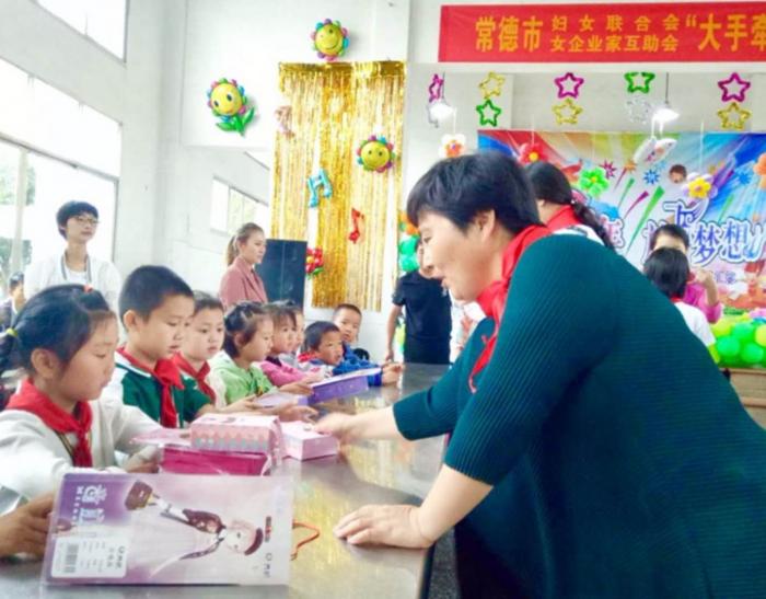 市女企业家互助会会长高绪秀为留守儿童送礼物.jpg