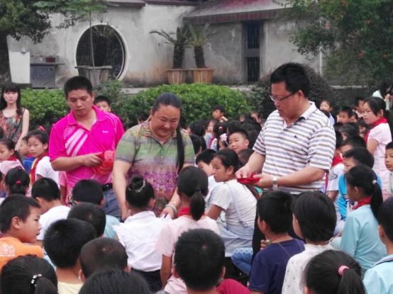 邓冬玉在给学生发放助学金.png