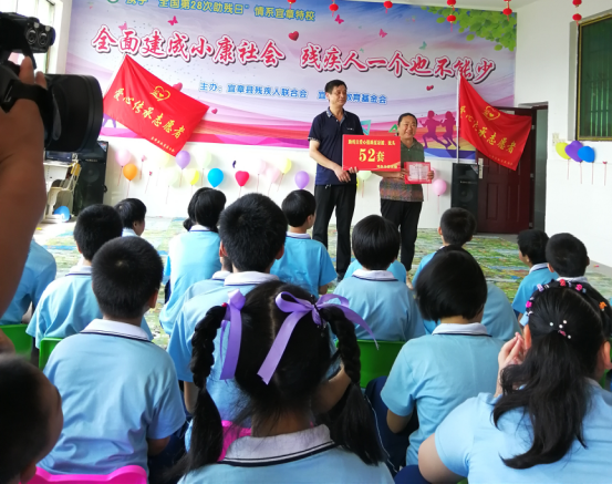 邓冬玉在特殊学校捐赠.png