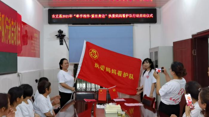 县妇联主要负责人向河西社区执委妈妈看护队授旗.jpg
