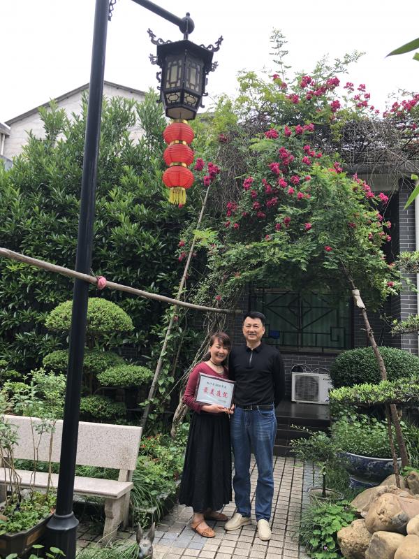 高明家庭获得县妇联颁发的2020年度最美庭院，回家后，两夫妻喜滋滋在自家庭院合影.jpg